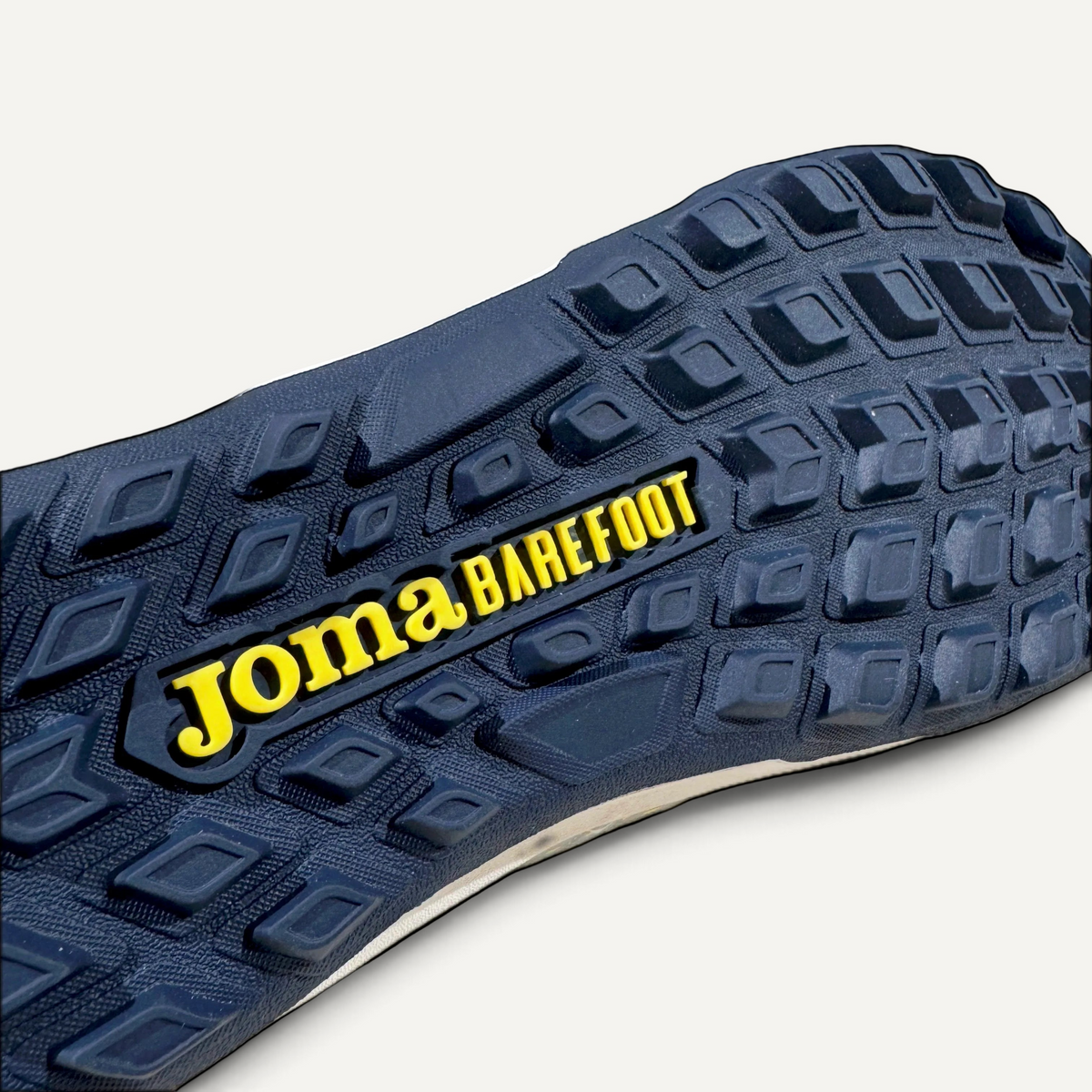 Suela multitaco gris de bota de futbol zoireo Joma Barefoot Gol con logo amarillo para cesped artificial
