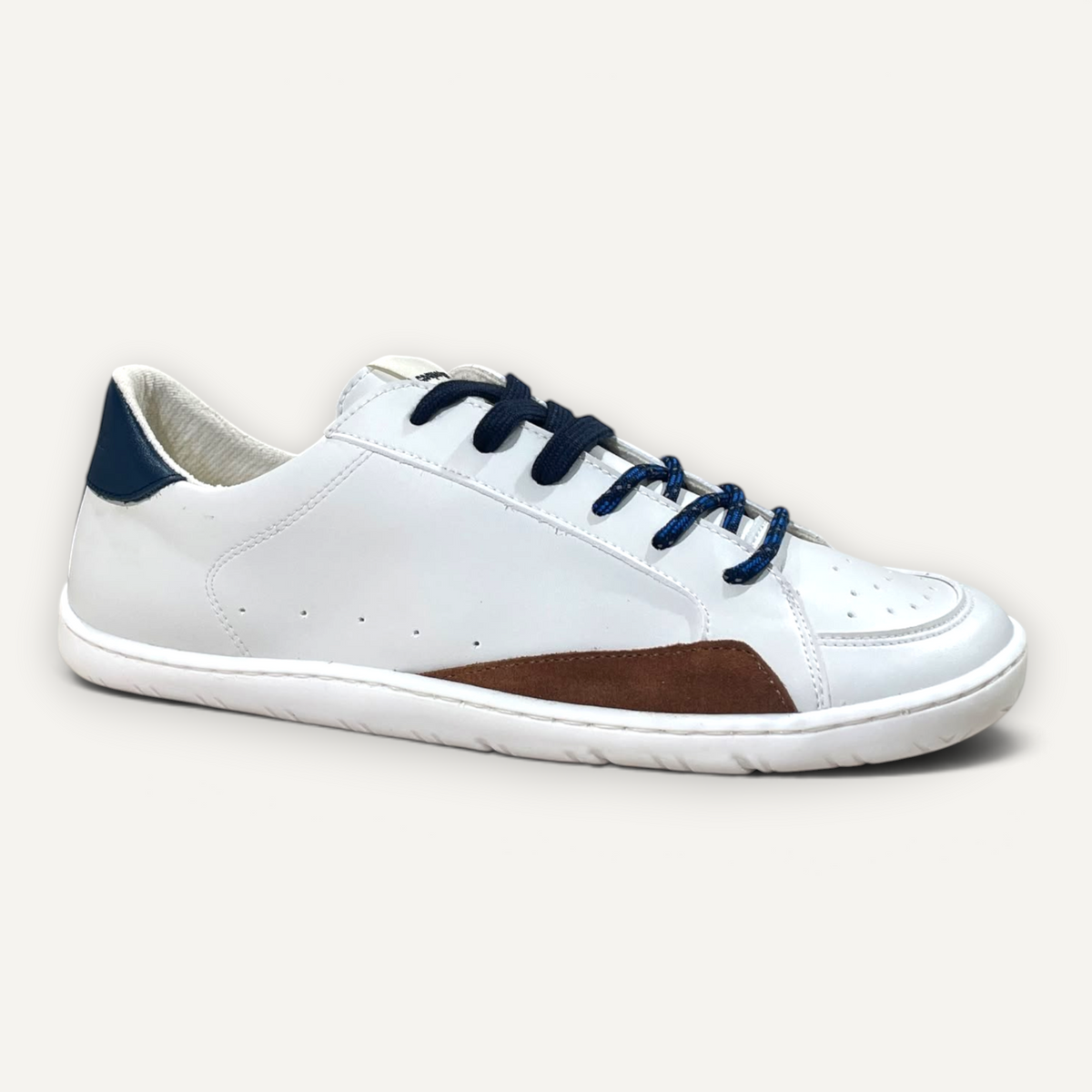 Zapatillas barefoot zoireo Coqueflex Sia blancas con detalles en azul marino y marrón en una tienda de calzado