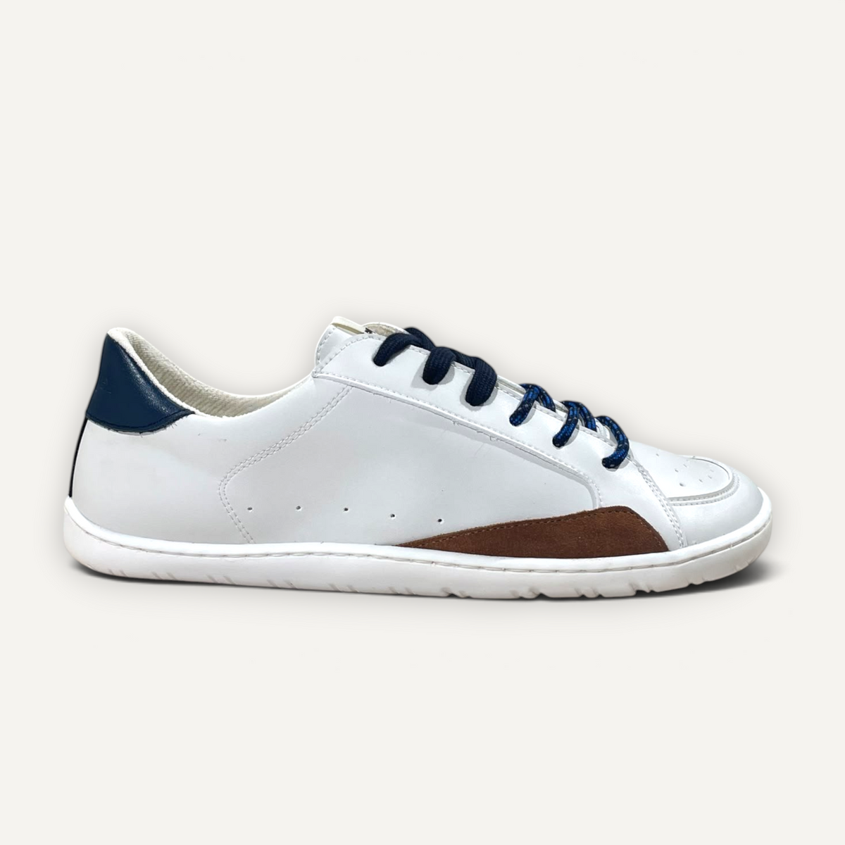 Zapatillas barefoot zoireo Coqueflex Sia blancas con detalles en azul y marrón, diseño minimalista de perfil bajo.